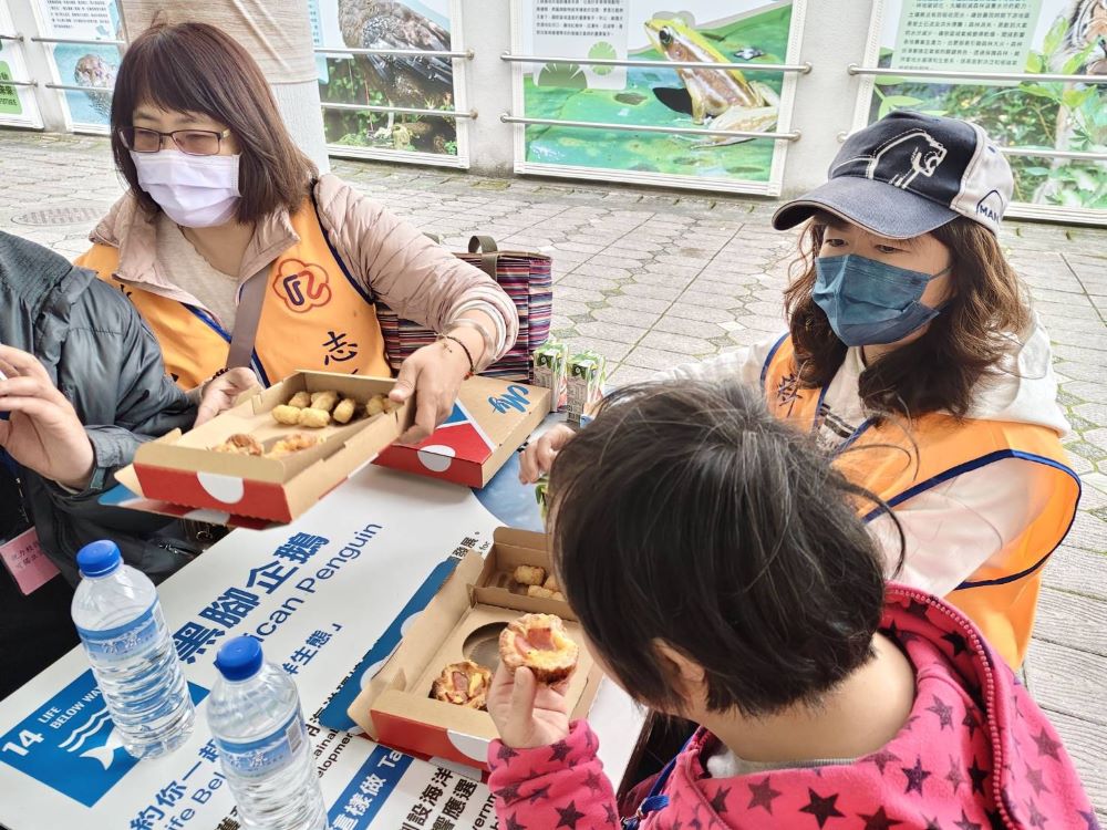 《圖說》榮欣志工協助身障院生用餐，享用美味Pizza，現場氣氛溫馨融洽。〈新北榮服處提供〉