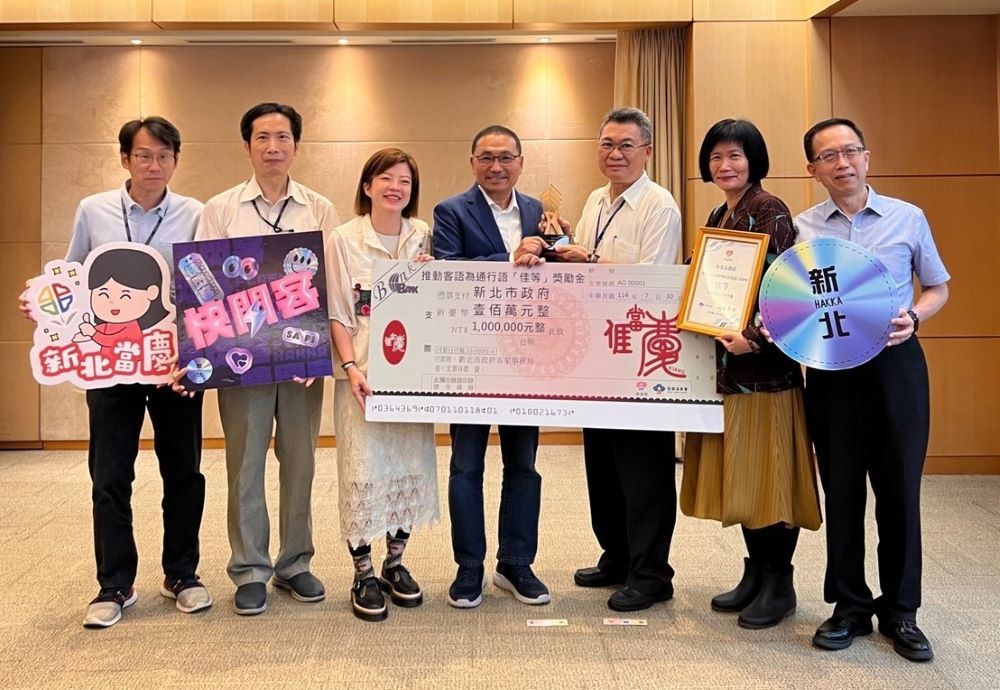 《圖說》新北5年5度獲獎，持續榮獲客家委員會推動客語為通行語之佳等暨獎勵金100萬元，客家局長劉冠吟(左3)率團隊在市政會議獻獎予侯友宜市長(左4)，右一客家局主秘巫宗仁。〈客家局提供〉