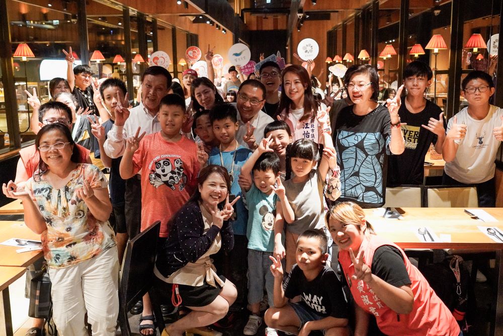 饗食天堂攜手新北公益餐會 百位〈小衛星〉啖佳餚 3 《圖說》饗食天堂攜手新北社會局舉辦公益餐會,邀百位小衛星兒少用餐。新北市長侯友宜驚喜現身,連續兩年促成餐會的議員江怡臻〈後排右二〉、社會局長李美珍〈後排右一〉等人,與小衛星兒少、照顧者們開心合影。〈社會局提供〉