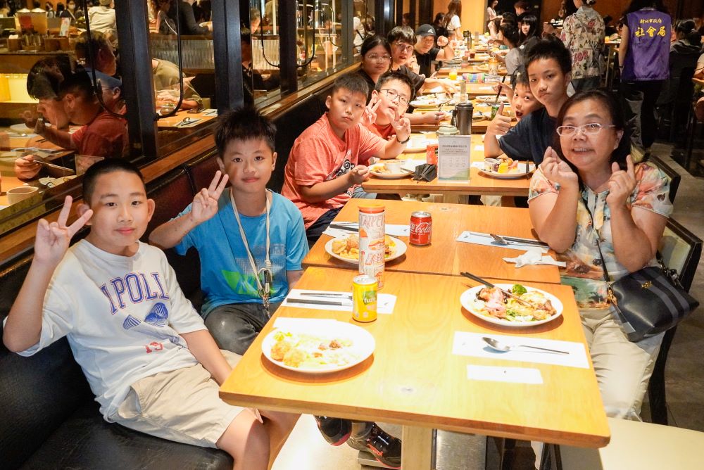 饗食天堂攜手新北公益餐會 百位〈小衛星〉啖佳餚 4 《圖說》小衛星兒少們開心比「YA」期待享用美食。〈社會局提供〉