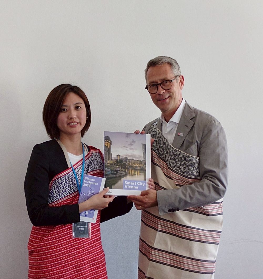 《圖說》維也納市政府文化部副處長Daniel Löcker(右)致贈書籍予新北市原民局長林瑋茜(左)，新北市原民局也回贈烏來在地工坊製作之披肩予副處長。〈原民局提供〉