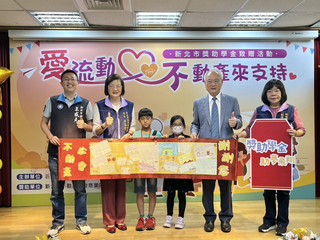 獲得獎學金的學生們手寫感謝卡，獻給新北市不動產開發商業同業公會廖志鴻理事長右2，並與新北市議員王威元左1、社會局長李美珍左2及副局長吳淑芳右1合影